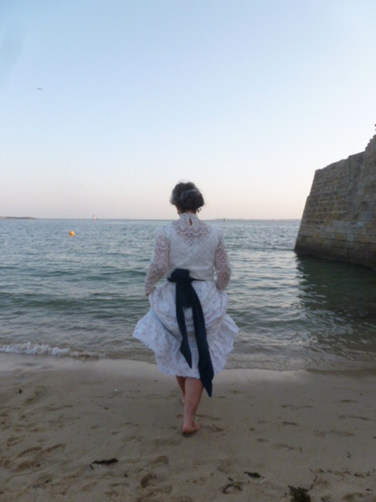 Participants en costumes Belle Époque sur la plage au coucher du soleil
