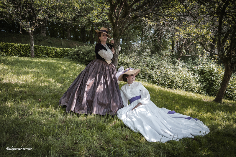 Participants en costumes historiques avec touches violettes dans un verger